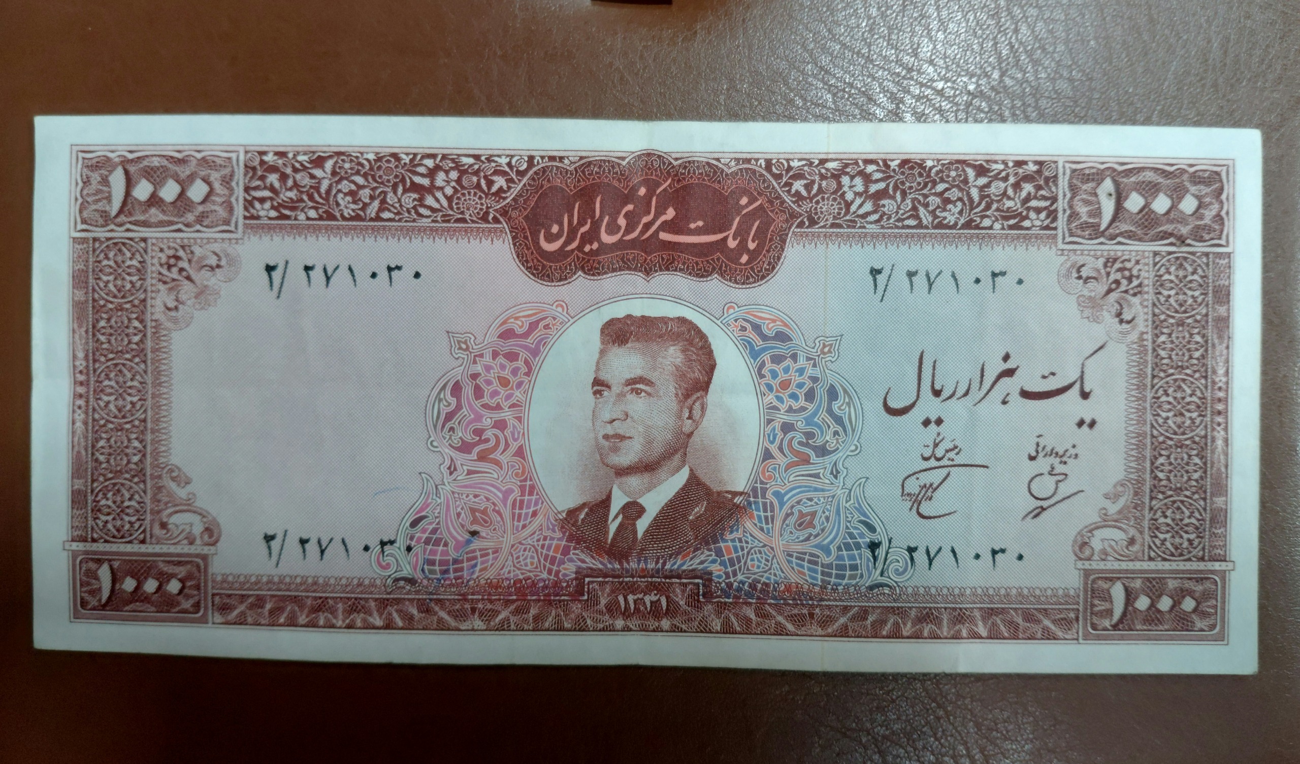 1000 ریال عکس وسط تا دارد و یک سوراخ و خودکاری