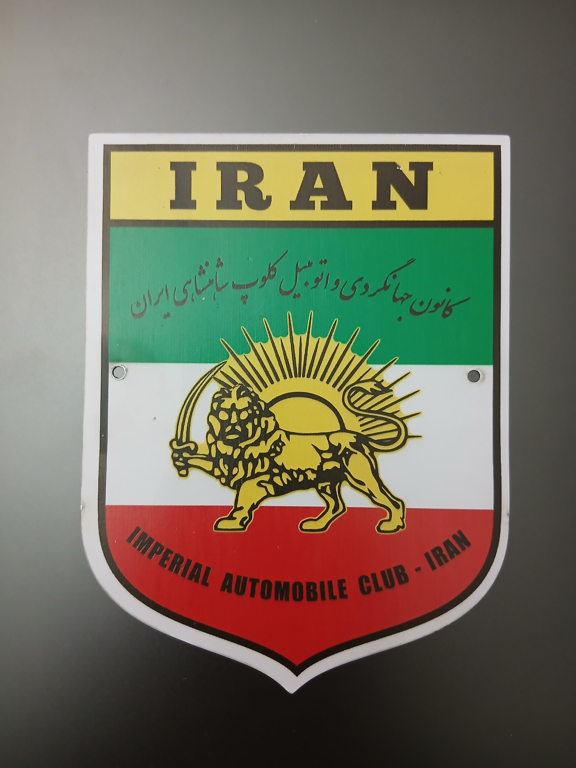 آرم فلزی بزرگ جهانگردی جلو پنجره پیکان نیسان