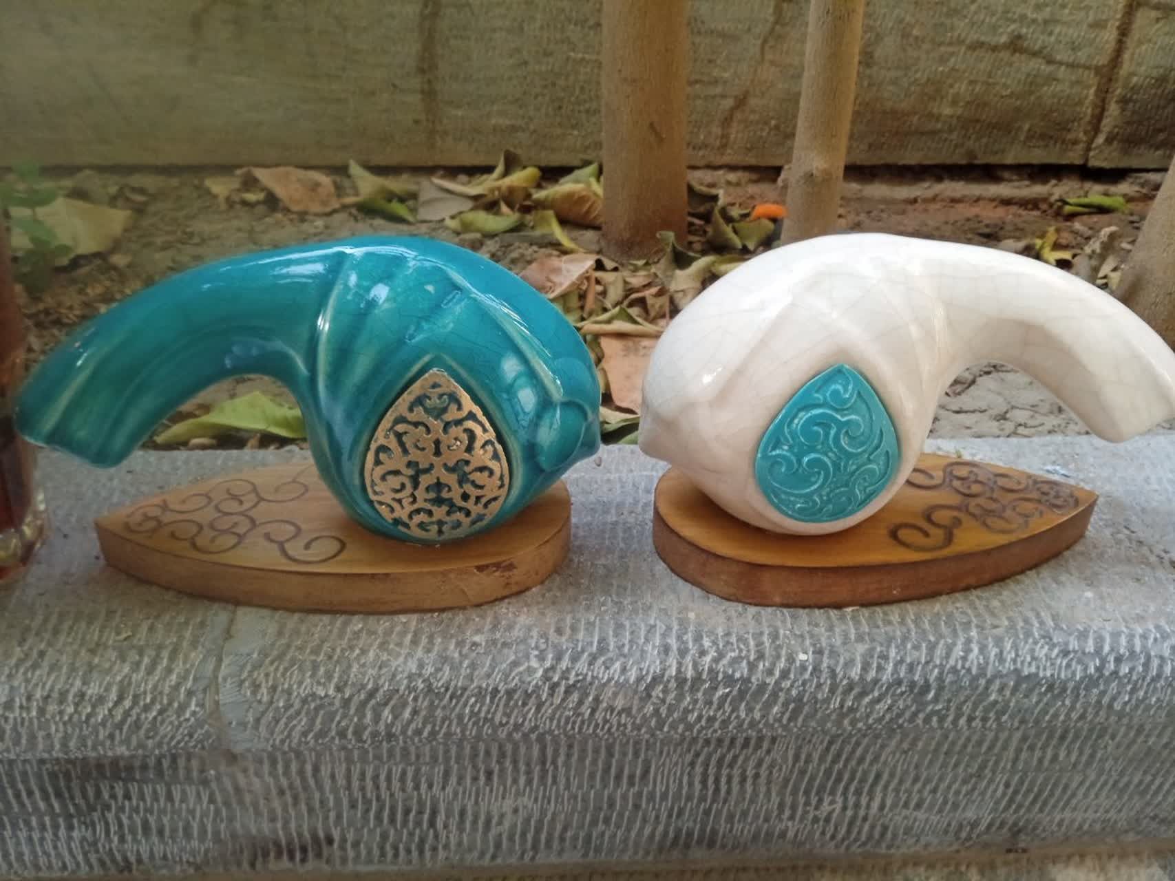 یک جفت مجسمه انتزاعی ماهی روی پایه چوب
